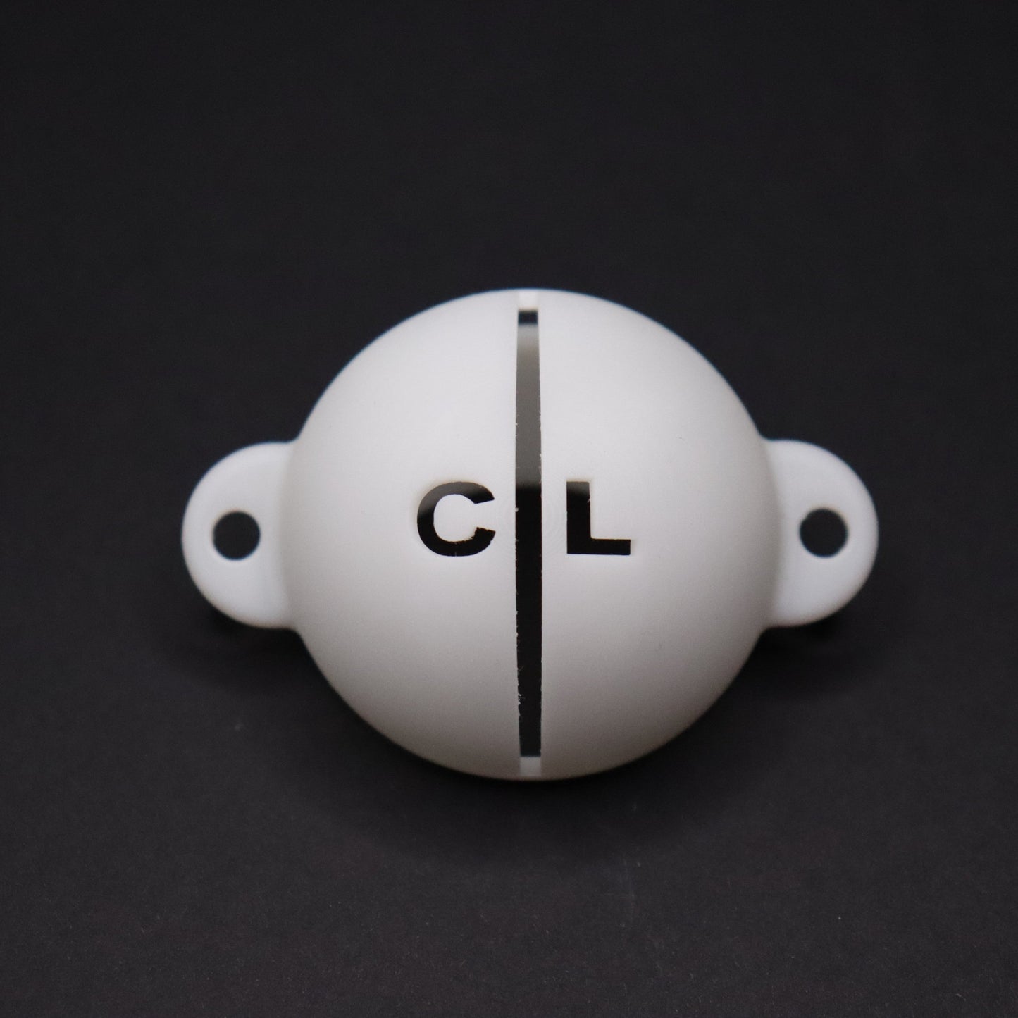Golf ball marker stencil manufactured via 3D printing in white plastic material. Two letters for initials, one on each side of an alignment line for putting