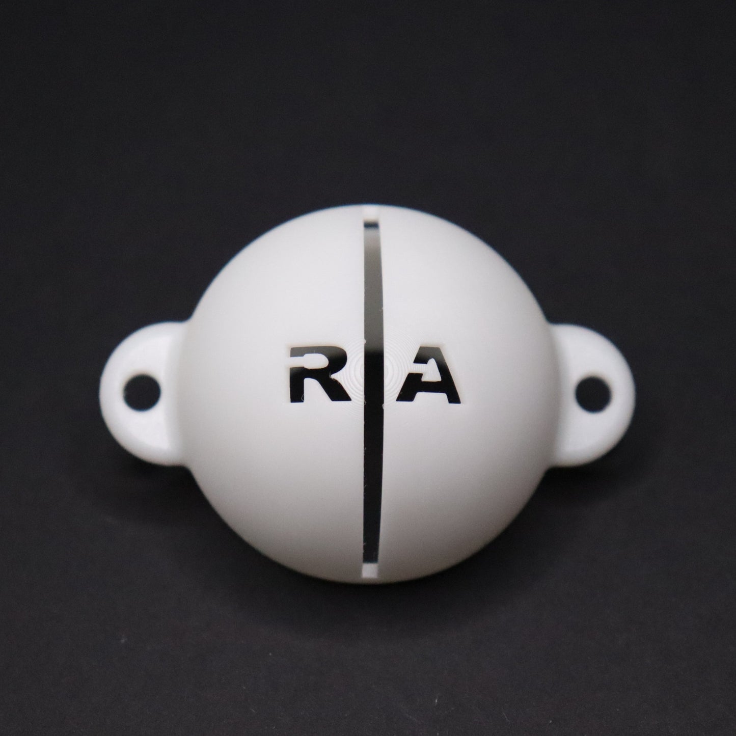 Golf ball marker stencil manufactured via 3D printing in white plastic material. Two letters for initials, one on each side of an alignment line for putting